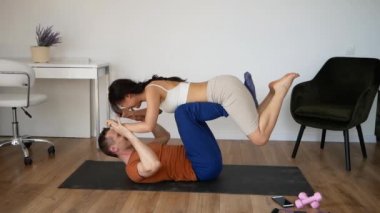 Spor Çifti, evde akro-yoga egzersizi yaparken eğleniyor.
