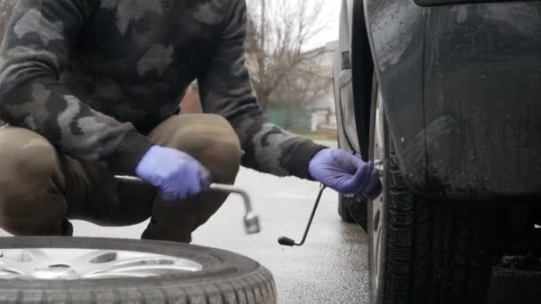 Junger Mann Wechselt Das Rad Des Autos Auf Der Straße — Stockvideo