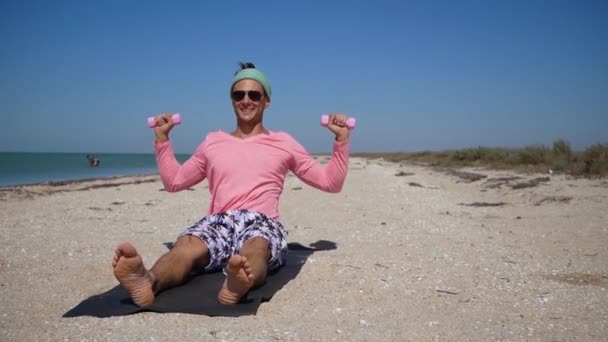 Zabawny Młody Człowiek Różowym Robi Ćwiczenia Fizyczne Plaży — Wideo stockowe