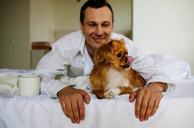 Yakışıklı adam evinde köpeğiyle dinleniyor.