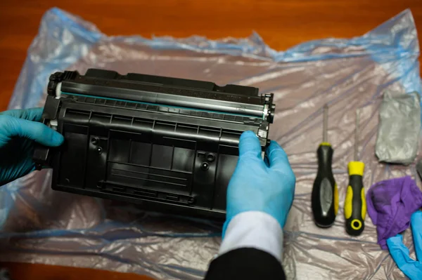 Hands in gloves Repairing Toner Cartridge.