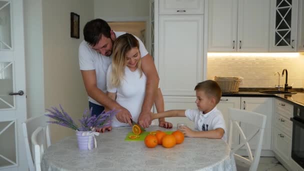 Szczęśliwa Młoda Rodzina Ciężarna Matka Chłopcem Jej Mąż Jedzenie Pomarańczowy — Wideo stockowe