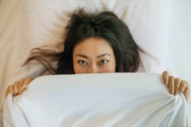 Beyaz çarşaflarla Yatakta Uyuyan Güzel Asyalı Kadın.
