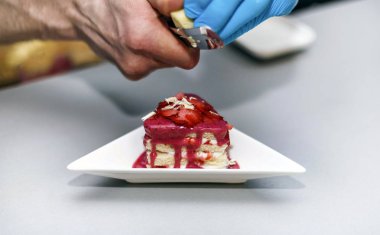 Çilek ve krema, bir Beyaz Dolgulu bisküvi plaka ve beyaz çikolata serpilir