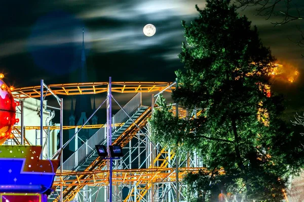 Gece cityscape ve bir eğlence parkı aydınlatma