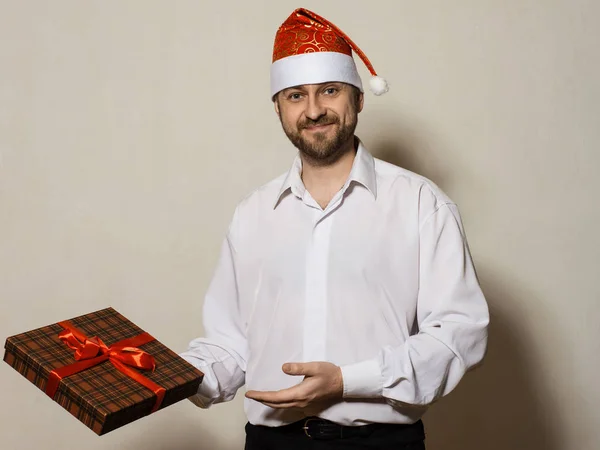 Schöner Mann in Weihnachtsmütze mit Geschenkschachtel — Stockfoto