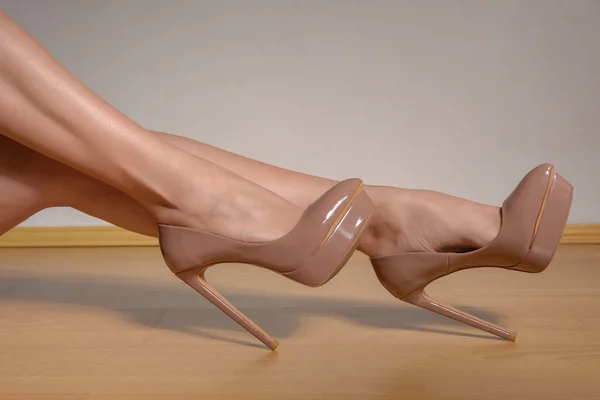 茶色の漆塗りの高いヒールの靴を身に着けている女性の脚線美 — ストック写真
