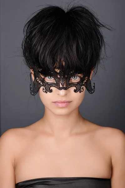 Vacker ung kvinna i svart mystisk spets venetiansk mask. — Stockfoto
