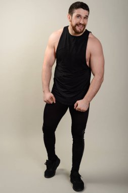 Kendine güvenen genç atletik adam kameraya seyir spor giyim istekli. Tam vücut uzunluğu portre studio beyaz arka plan üzerinde