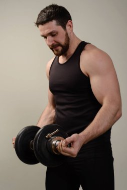 Kaslı erkekler dumbbells ile egzersiz. Alternatif pazı bukleler gerçekleştiriyor.