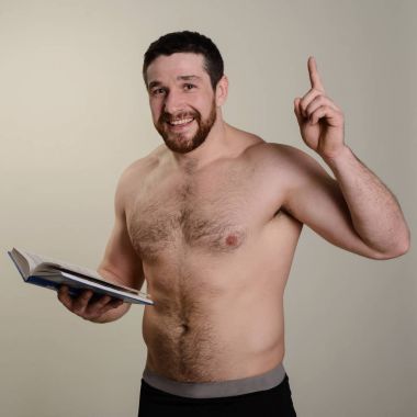 Acımasız neşeli sakallı atlet bir kitapla parmağını en üstünde işaret ediyor