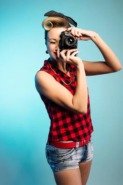 Pin Up girl taking photos with vintage camera