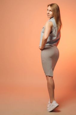 Gülümseyen kız çizgili bir elbise ve geri duran bir kot yelek