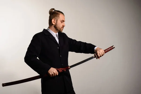 Homem de negócios masculino puxa uma espada de samurai japonês — Fotografia de Stock