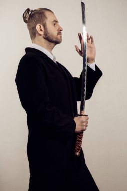 bir Japon kılıç ile siyah elbiseli genç işadamı samuray