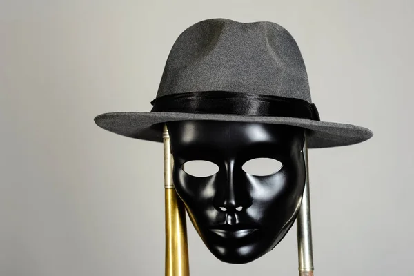Czarny Teatr maska i kapelusz wiszące na rury mosiężne — Zdjęcie stockowe