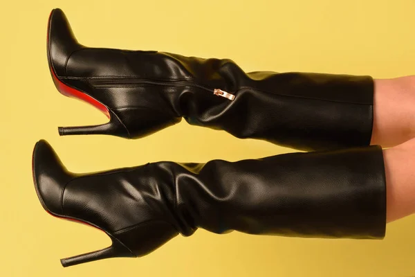 Czarne buty obcasie na kobiece stopy na żółtym tle — Zdjęcie stockowe