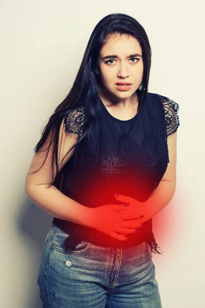 Woman having stomach pain. The place of pain is marked in red Isolated on white background.