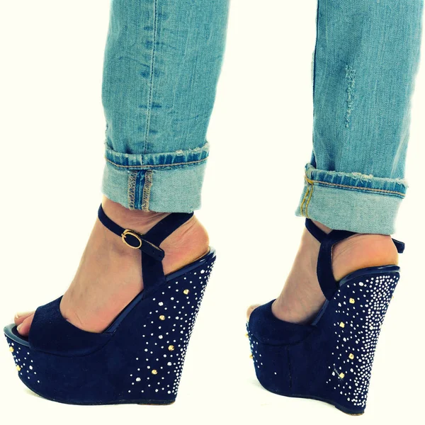 girl in jeans and high heels with studs and rhinestones on white background