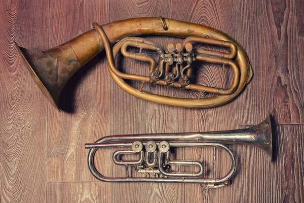 old brass wind instrument and horn  on a wooden background. studio