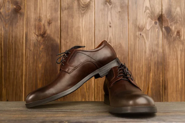 Fashionable men's classic brown shoes on a wooden background - image