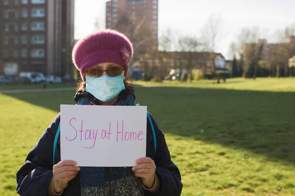 old person with sign drawing of quarantine