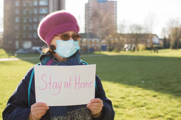 old person with sign drawing of quarantine