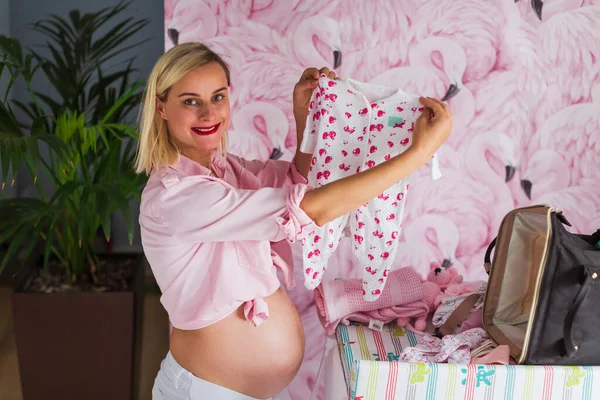 Kobieta Ciąży Odzieżą Dla Niemowląt Ubrania Przygotowujące Nowego Dziecka — Zdjęcie stockowe