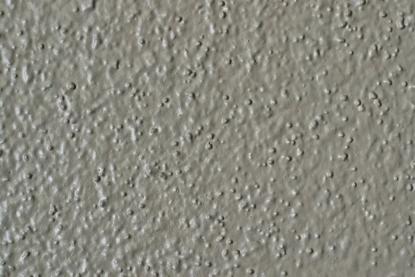 Painted drywall single color image with rough textures. Colors are similar to Tortilla, Hazel Wood, Gray and Tan. Also has the appearance of cement.