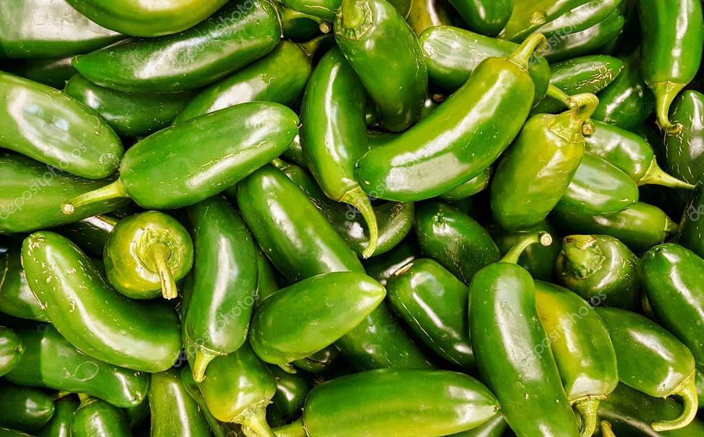 Pimientos Jalapeños verdes crudos en una pila en un puesto de mercado