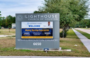 Humble, Texas/USA 11/28/2019: Lighthouse Church of Houston road sign by a sidewalk in Humble, TX with a park area in the background. It was founded in 2009. clipart