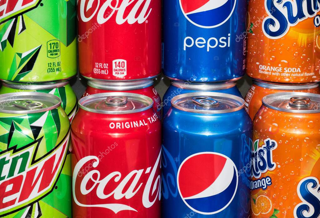 Houston, Texas/USA 12/01/2019: Assorted unopened carbonated drink cans in various flavors stacked close together. Coca Cola, Mountain Dew, Sunkist and Pepsi.