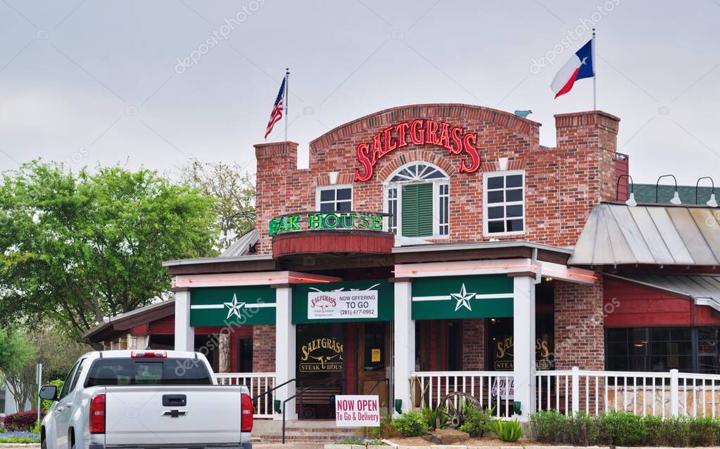 Houston, Texas/USA 03/25/2020: Saltgrass restaurant exterior in Houston, TX with a vehicle parked out front. Historic American restaurant serving steaks, chicken and seafood with a rustic feel.