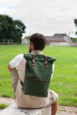 sırt üstünde onun sırt çantası ile oturan adam