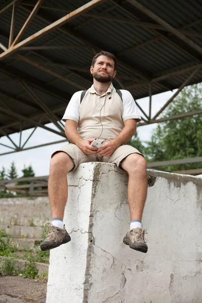 Man sitter med ryggsäck på ryggen — Stockfoto