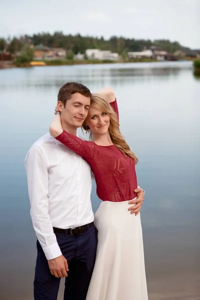 Matrimonio coppia in piedi e abbracci vicino lago — Foto Stock