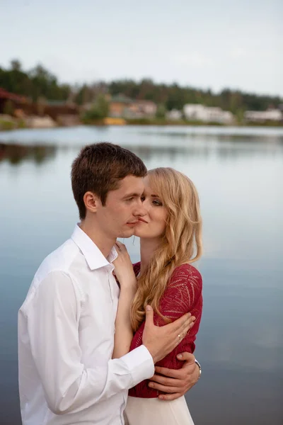 Ślub pary stojącej i całując w pobliżu jeziora — Zdjęcie stockowe