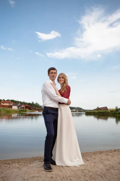 Couple de mariage debout et câlin près du lac — Photo