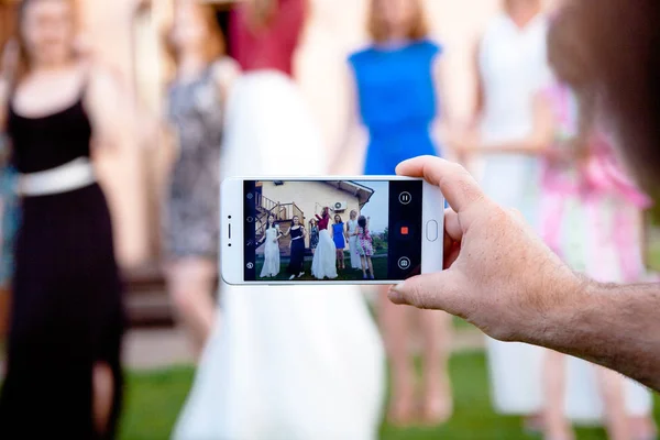 Homem usar smartphone para tirar fotos de meninas dançando — Fotografia de Stock