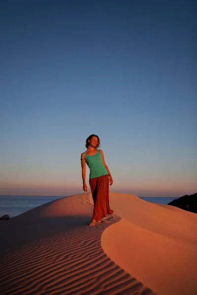 Beautiful woman walk by sand dunes in desert — Stock Photo, Image