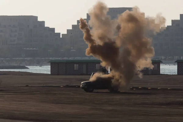 戦争中の車への軍事攻撃または爆弾は、混乱の中で爆発と煙を引き起こします。軍事的概念。力、力、力、火、爆発. — ストック写真