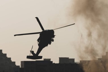 Ordu helikopteri savaş ve çatışmada duman, kaos ve yıkıma doğru uçuyor. Askeri güç kavramı, güç, güç, hava saldırısı. Dikey Görünüm.