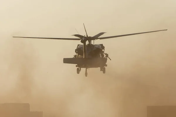 Helikopter wojskowy startuje w walce i wojnie lecąc w kierunku dymu, chaosu i zniszczenia. Wojskowa koncepcja władzy, siły, siły, nalotu. Widok na portret. — Zdjęcie stockowe