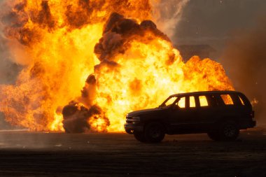 Askeri bir saldırı ya da tankları olan bir SUV 'a yapılan bombalı saldırı kasabada kargaşaya ve patlamaya neden oldu. Askeri savaş konsepti. Güç, güç, güç, ateş, patlama.