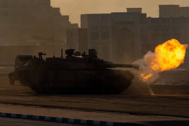 Ordu tankları savaş ve askeri çatışma sırasında çöl kasabasında ateş edip araba kullanıyordu. Askeri savaş ve patlama kavramı.