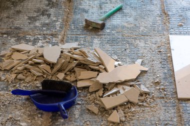 Kırık seramik fayansların giriş kapısının yenilenmesi. Kiremitleri kırıyorum. Havan ve çimentoyla döşemeden önce döşeyip kırılan parçaları temizliyorum..