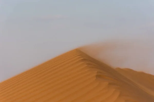 Zonsondergang in de woestijn over een textuur en patroon richel met blazen zand maken spectaculaire veranderende vormen. Verenigde Arabische Emiraten. Desert Concept. — Stockfoto