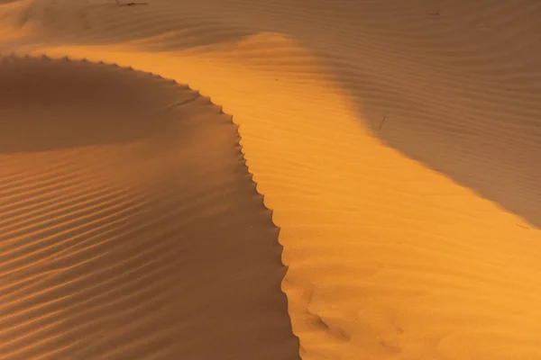 Pôr do sol no deserto através de uma crista texturizada e modelada fazendo formas de mudança espetaculares. Emirados Árabes Unidos. Conceito do deserto . — Fotografia de Stock