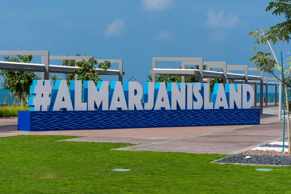 Señal azul de la isla de Marjan en Ras al Khaimah, paseo marítimo de los Emiratos Árabes Unidos a lo largo del Golfo Pérsico en un día de cielo azul con palmeras y plantas verdes ." —  Fotos de Stock