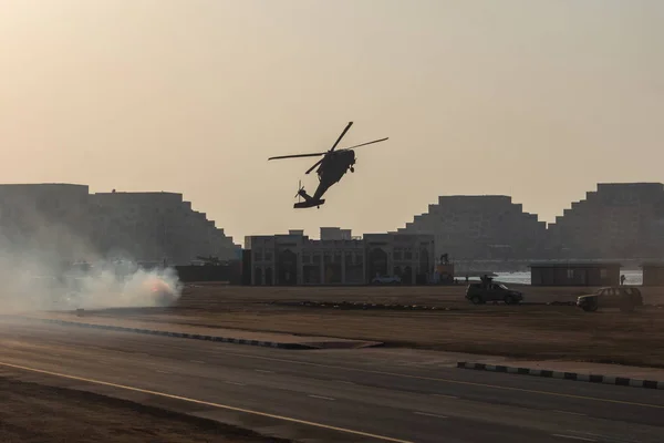 Military combat and war with helicopter flying into the chaos and destruction. Military concept of power, force, strength, air raid.